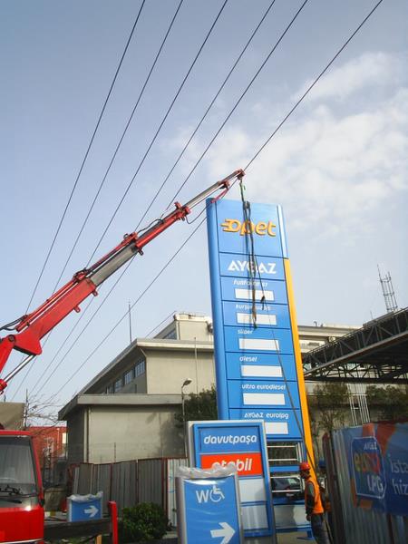 Gerilim hattı altında opet tabelası montajı.